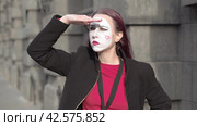 Mime young woman in a black coat shading her eyes searching looking around herself. Стоковое видео, видеограф EStarodubov / Фотобанк Лори