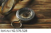 Close-Up of a Classic Compass Beside a Rope on a Wooden Surface During Daylight. Стоковое видео, видеограф Сергей Толмачёв / Фотобанк Лори