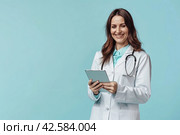 A horizontal banner with a nurse in a white coat. She smiles, holds a tablet with notes in her hands and looks at the camera. Place for the inscription. Стоковое AI-изображение, AI-художник Ярославский Максим / Фотобанк Лори