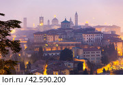 Illuminated Bergamo upper city in misty winter twilights, Italy. Стоковое фото, фотограф Яков Филимонов / Фотобанк Лори