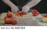 The cook cuts the bell peppers in the kitchen of the restaurant. Стоковое видео, видеограф Strunov David / Фотобанк Лори