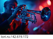 Saxophonist in close-up on the stage in red and blue tones. The concept of jazz. Стоковое AI-изображение, AI-художник Ярославский Максим / Фотобанк Лори