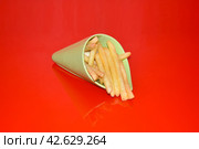 Картофель фри в пластиковом рожке на красном фоне. Стоковое фото, фотограф Михаил Киселев / Фотобанк Лори