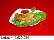 Жареный окорочок с овощами и соусом в белой тарелке на красном зеркальном фоне. Стоковое фото, фотограф Михаил Киселев / Фотобанк Лори