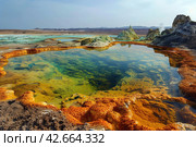 Geothermal water outlet with bright mineral deposits in desert volcanic area. Стоковое AI-изображение, AI-художник Евгений Харитонов / Фотобанк Лори