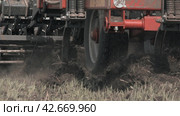 Tractor plowing a field. Close-up shot seeder planting crops in slow motion mode. Крупный план прицепного устройства для вспашки земли и посева семян. Замедленная съемка. (2017 год). Редакционное видео, видеограф EStarodubov / Фотобанк Лори