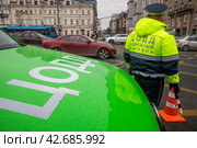 Сотрудник ЦОДД обеспечивает безопасность дорожного движения на Тверской улице в центре города Москвы, Россия (2024 год). Редакционное фото, фотограф Николай Винокуров / Фотобанк Лори