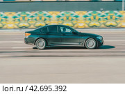 Black BMW 5 series car on the city road. Fast moving vehicle on the street. Dusty auto needs to wash. Sedan driving along the street in city with blurred background. Редакционное фото, фотограф Константин Григорьев / Фотобанк Лори