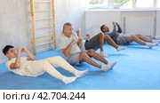 Group of men performing combat strikes sitting during group training. Стоковое видео, видеограф Яков Филимонов / Фотобанк Лори