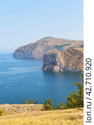 Baikal Lake in August misty day. Beautiful calm landscape of Olkhon Island. View from Cape Sagan-Khushun to rocky Cape Damnuriy. Natural background. Summer holidays and outdoor recreation. Стоковое фото, фотограф Виктория Катьянова / Фотобанк Лори