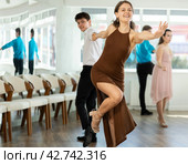 Smiling girl dancing lindy hop with partner in dance studio. Стоковое фото, фотограф Яков Филимонов / Фотобанк Лори