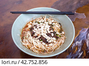 Sichuan style noodles like spicy noodle with chicken gizzard, minced, vegetables and peanut, Chinese cuisine (2018 год). Стоковое фото, фотограф VittoriaChe / Фотобанк Лори