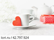 Valentine's Day. Morning breakfast for two with tea, gift, flowers. Red felt heart. Стоковое фото, фотограф Natalia Gdovskaia / Фотобанк Лори