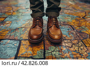 Legs of a man in stylish brown leather lace-up shoes standing on a surface covered with a large map. The map appears to be ancient, with images of lands, bodies of water and names in Latin, done in a traditional style. Стоковое AI-изображение, AI-художник Анна Кривицкая / Фотобанк Лори