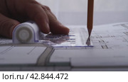 The designer draws with a compass and ruler on the drawing. Стоковое видео, видеограф Igor Skripachev / Фотобанк Лори