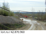 Экскаватор, грузит машину щебнем  вдалеке (2024 год). Редакционное фото, фотограф Роман Лукьянов / Фотобанк Лори