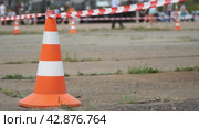 Fencing tape and road cone on the background of passing people. Selective focus. Стоковое видео, видеограф Александр Прошкин / Фотобанк Лори