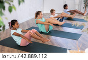 African girl perform boat asana - Paripurna navasana. Comprehensive hatha yoga class in mini group. Стоковое фото, фотограф Яков Филимонов / Фотобанк Лори