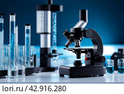 Science chemical laboratory research and development concept. Close-up of microscope with test tubes, chemical research, developed in the laboratory for research products concept. Copy ad text space. Стоковое AI-изображение, AI-художник Aleksandr Golubev / Фотобанк Лори