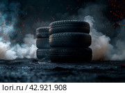Автомобильные шины в темном дымном помещении, освещенные рисующим светом. Стоковое AI-изображение, AI-художник Максим Коломыченко / Фотобанк Лори