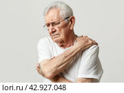 Senior man with shoulder, upper arm pain. Human body health problem banner. Elderly male enduring awful ache. Upset old man with muscle, nerve pain symptom holding hand on painful zone injured point. Стоковое AI-изображение, AI-художник Марина Демидюк / Фотобанк Лори