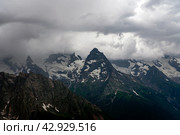 View of the Great Caucasian Ridge opening from the Upper station of the cable car system of the Dombay ski resort on a summer day, Karachay-Cherkessia, Russia. Стоковое фото, фотограф Ula Ulachka / Фотобанк Лори