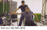 Disabled man training on simulators. Стоковое видео, видеограф Chudakov_Ivan / Фотобанк Лори