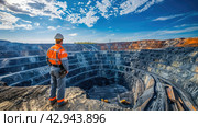 Rear view of a mining engineer standing on top of a huge deep quarry. Стоковое AI-изображение, AI-художник Александр Довянский / Фотобанк Лори