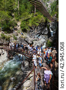 ARSHAN VILLAGE, TUNKINSKIY DISTRICT, BURYATIA, RUSSIA -  August 12, 2023: Many tourists go on Eco Health Path to popular waterfall on mountain river Kyngarga in Tunkinskiy Park reserve on summer. Редакционное фото, фотограф Виктория Катьянова / Фотобанк Лори