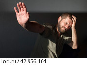 The man at home suffers from heat, bright sunlight and headaches. Headache, hangover and alcoholism concept. Hot weather, meteorological dependence. Стоковое фото, фотограф Александр Довянский / Фотобанк Лори