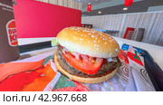 Moscow April 10 2024, Big burger with two patties on a tray in burger king. Burger on a tray in fast food restaurant close-up. Fast food restaurant and self-service checkouts. Редакционное фото, фотограф Скрипачев Антон / Фотобанк Лори