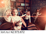 Group of friends trying to find solution of quest in escape room with antique furnitures. Стоковое фото, фотограф Яков Филимонов / Фотобанк Лори
