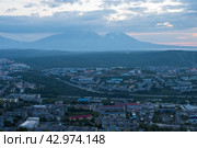 Город Петропавловск-Камчатский, Камчатский край, Дальний Восток России. Утренний городской пейзаж. Вид сверху на здания и улицы города. Жилые городские районы в сумерках на рассвете. Вдалеке вулканы. Путешествие на Камчатку. Стоковое фото, фотограф Андрей Степанов / Фотобанк Лори