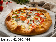 Homemade savory galette with vegetables, wheat pie with tomatoes, zucchini, side view. Стоковое фото, фотограф Natalia Gdovskaia / Фотобанк Лори