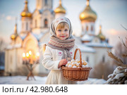 Happy bright Easter. Christianity. Portrait of a three-year-old girl in a Russian folk dress and shawl with a wicker basket with Easter eggs in her hands against the background of an Orthodox church. Стоковое AI-изображение, AI-художник Photojuli / Фотобанк Лори