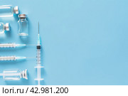Syringe and glass vial on blue background flat lay. Medical Vials group, needles, ampoules, bottle with medicine, vaccine. Disease treatment. Creative Banner. Anti-aging beauty injections. Vaccination. Стоковое AI-изображение, AI-художник Марина Демидюк / Фотобанк Лори