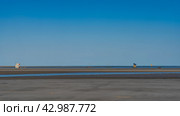Low tide. The streamlet formed on the exposed sandy seabed. Sailing boats and pirogues are visible in the ocean in the distance. Clear blue sky. Copy space. Madagascar. Morondava. Mozambique Channel. Стоковое фото, фотограф Вера Ивановна Кубарева / Фотобанк Лори