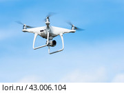 Uncrewed aerial vehicle UAV drone quad copter or quadrocopter DJI with digital camera flight in blue sky and photographs around (2019 год). Редакционное фото, фотограф А. А. Пирагис / Фотобанк Лори