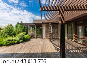 Wooden terrace with gazebo at the house on a clear sunny day. Beautiful view of the courtyard landscape. Стоковое фото, фотограф Алексей Климкин / Фотобанк Лори