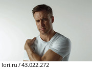 Mature man with pain in shoulder upper arm. Human body health problem banner. Male adult is enduring awful ache. Upset person with muscle nerve pain symptoms holding hand on painful zone injured point. Стоковое AI-изображение, AI-художник Марина Демидюк / Фотобанк Лори