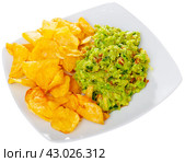 Beer snacks are laid out on plate - chips and portion of thick pasta sauce guacamole. Стоковое фото, фотограф Яков Филимонов / Фотобанк Лори