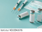 Syringe and glass vial on blue background table. Medical Vials group, needles, ampoules, bottle with medicines or vaccine. Disease treatment. Creative Banner. Anti-aging beauty injections. Vaccination. Стоковое AI-изображение, AI-художник Марина Демидюк / Фотобанк Лори