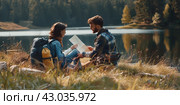Beautiful young tourist couple with map looking at the mountain lake. Summer trip in nature. Lifestyle, togetherness, active life concept. Travelers with backpacks relaxing after hiking. Tourism. Стоковое AI-изображение, AI-художник Марина Демидюк / Фотобанк Лори