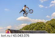 Молодой человек участвует в соревнованиях по BMX на велосипеде в Парке Горького в Москве/ Young man doing tricks in the air on a BMX bike. BMX rider (2018 год). Редакционное фото, фотограф Iva Noel / Фотобанк Лори