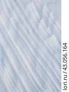 Beautiful winter background with snowy ground. Natural snow texture. Wind sculpted patterns on snow surface. Стоковое фото, фотограф Андрей Степанов / Фотобанк Лори