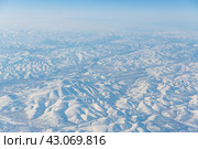 Вид с воздуха на заснеженные горы. Зимний горный пейзаж. Колымское нагорье, Магаданская область, Сибирь, Дальний Восток России. Отлично подходит для фона. Стоковое фото, фотограф Андрей Степанов / Фотобанк Лори