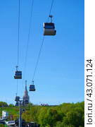 Cabins of the Moscow cable car on the background of the Vorobyovy Gory and the spire of Moscow State University. Russia. Moscow. 29.04.2024. Редакционное фото, фотограф Ярославский Максим / Фотобанк Лори
