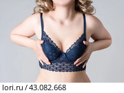 Blonde woman in blue push up bra on gray background, decollete area care. Стоковое фото, фотограф Станислав Тарко / Фотобанк Лори