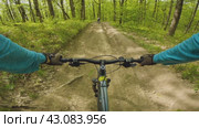 The essence of mountain biking. A cyclist speeds down a mountain in the woods on a bumpy road. The thrill and essence of mountain biking. First person view. There is another cyclist riding ahead. Стоковое видео, видеограф Воловодов Владимир / Фотобанк Лори