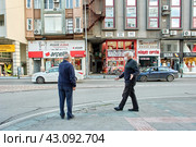 Two elderly people wear protective face masks while on city street as prophylaxis for coronavirus infection, senior men rush home on eve of curfew. (2021 год). Стоковое фото, фотограф Владимир Григорьев / Фотобанк Лори